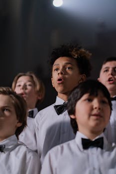 A diverse group of boys in bow ties performing in a choir.
