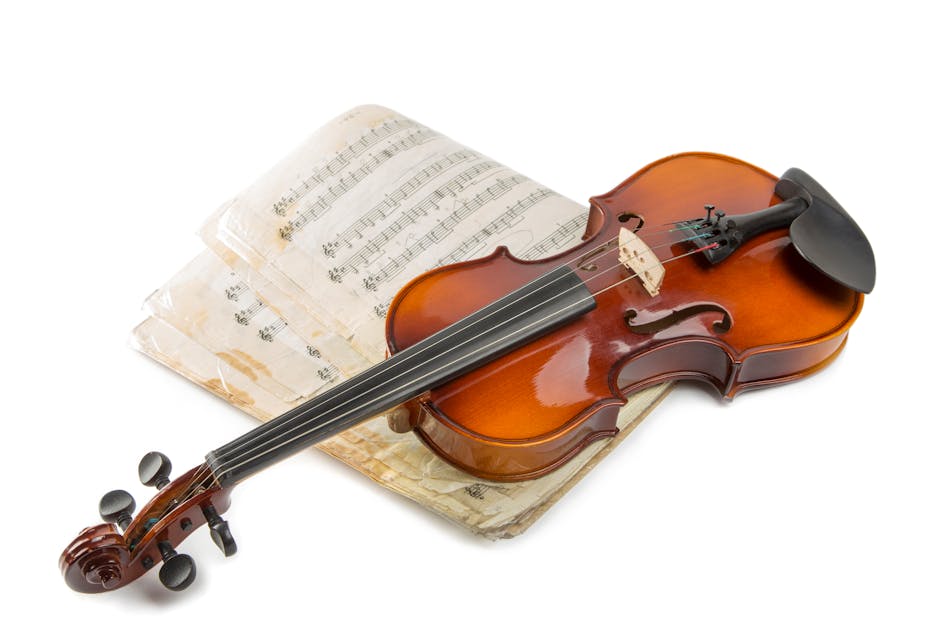 A beautiful violin resting on vintage sheet music, set against a clean white background.